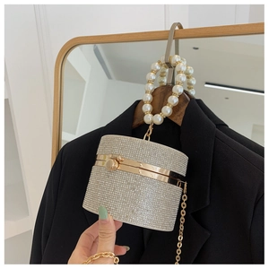 Detail of silver rhinestone cylinder evening bag with pearl handle on a blazer