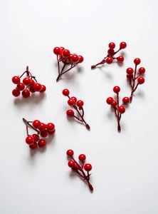 Detailed close-up of glossy artificial red holly berries for festive DIY holiday decor