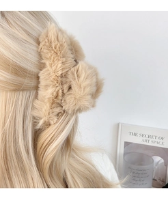 Detail of extra large plush shark hair claw clip in khaki faux fur on long hair