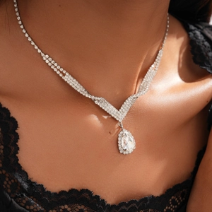 Close-up of luxury silver V-shaped necklace with a large teardrop pendant and crystals