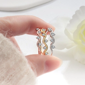 Elegant wave-shaped rings with sparkling crystals in rose gold, gold, and silver finishes