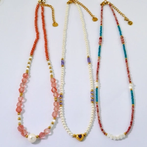 Three handmade beaded necklaces with natural stones, pearls and gold heart pendants
