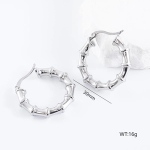 Detail of 30mm silver bamboo design irregular hoop earrings weighing 16g on stone decor