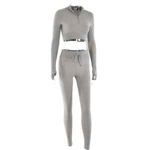 Detail of light grey ribbed sports set featuring a zipper collar top and thumbhole sleeves