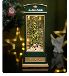 Close-up of vintage green telephone booth snow globe with glowing Christmas tree and snowman