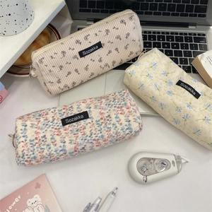 Detailed corduroy floral pencil cases in three patterns on a desk with stationery