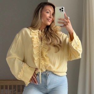 Sweet yellow chiffon blouse with V-neck ruffles and long sleeves shown on a model