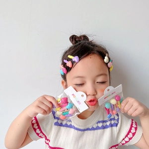 Close-up of a girl wearing colorful candy-colored heart and round hair clips