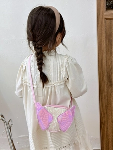 Pink cartoon girls crossbody bag with angel wings and sequins shown on a child model