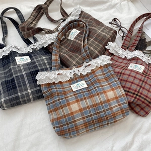 Flat lay of four plaid wool tote bags in various colors with delicate white lace trim