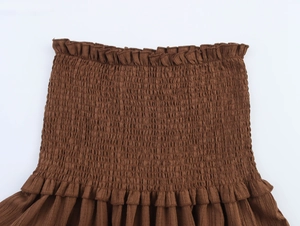 Detail view of coffee brown crop top featuring ruched elastic fabric and ruffled edges