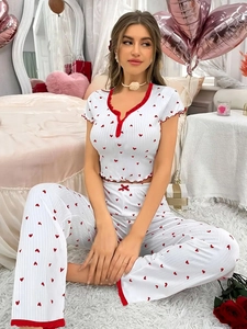Close-up of red heart print and delicate lace trim on white rib-knit pajama fabric