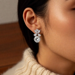 Dettaglio di modella con orecchini a fiore in argento e zirconi bianchi brillanti