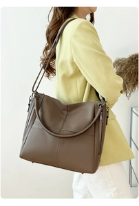 Lifestyle shot of a large brown pebble leather tote bag with dual handles and strap