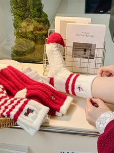 Detailed view of winter socks featuring festive snowman embroidery and thick coral fleece texture