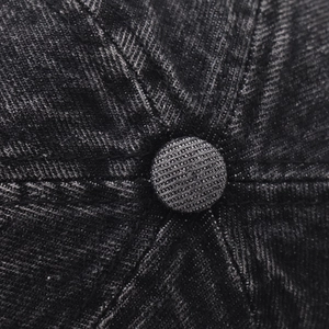Détail de la calotte de casquette en denim délavé avec coutures et bouton recouvert