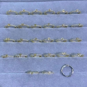 Set of 26 English letter rings plated in 18K gold with inlaid cubic zirconia on display