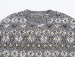 Detail of Fair Isle knit sweater with grey snowflake patterns and soft mohair texture