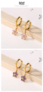 Detail of gold flower earrings with pink and purple zircon petals on display