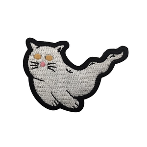 Close-up of white ghost cat embroidered patch with yellow eyes and black borders