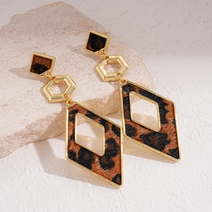 Retro geometric leopard print earrings with gold metal frame on a textured stone base