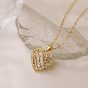 Detail of gold heart pendant necklace featuring rectangular and round cubic zirconia stones