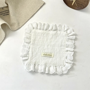 Macro shot of white cotton place mat with heart lace edges and Sozakka label detail