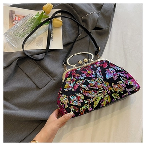Detail of sequin shell bag featuring gold metal handle and colorful glittering fabric