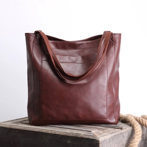 Détail du sac cabas vintage en cuir ciré marron avec poche frontale et texture riche