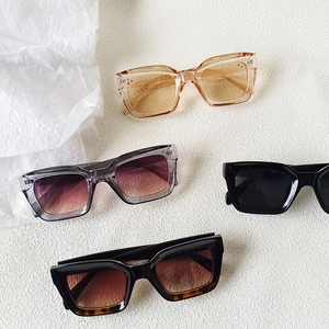 Fashionable square oversized sunglasses in various colors on white leather background