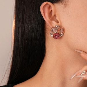 Macro shot of resin flower stud earrings with champagne pink gradients and small crystals