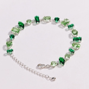 Detail of green zircon bracelet featuring alternating emerald stones and lobster clasp