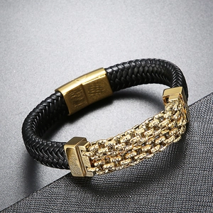 Detail of men's black braided leather bracelet with gold metal chain and magnetic clasp