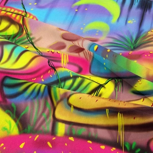 Close-up of vibrant mushroom tapestry fabric showing smooth texture and neon colors