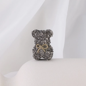 Detailed view of grey crystal bear charm with gold bow for DIY jewelry making
