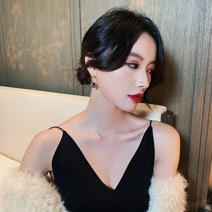 Elegant gold drop earrings with black round crystal charms worn by a model in soft lighting