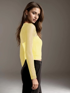 Detail of sheer mesh patchwork on yellow one-shoulder long sleeve top with slim fit