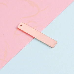 Macro view of a rectangular rose gold stainless steel tag with polished mirror finish