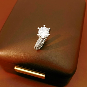 Détail macro d'une bague en zircon à six griffes sur un coffret à bijoux en cuir marron