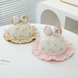 Detail of baby sun hats with fruit prints, lace edges, and decorative cherry bows
