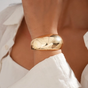 Close-up of minimalist 18k gold plated chunky open bangle on a model's wrist
