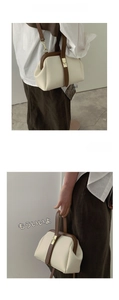 Detail of retro contrast handbag with metal clasp and adjustable leather shoulder strap