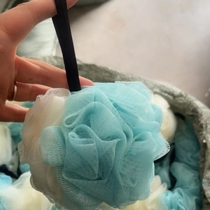 Large blue and white soft bath loofah sponge with black hanging ribbon for shower