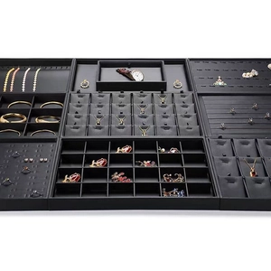 Close-up of black PU leather jewelry display tray with multiple storage compartments