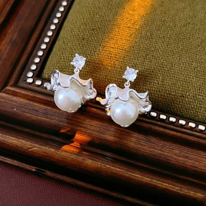 Détail macro de boucles d'oreilles feuille de ginkgo en argent avec perle et zircon
