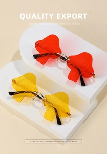 Detail of mushroom shaped rimless sunglasses with red and yellow lenses and gold metal frames