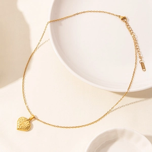 Macro view of textured heart pendant with 18k gold plating on elegant O-chain necklace