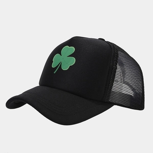 Close-up of black trucker hat with green shamrock print and breathable mesh design