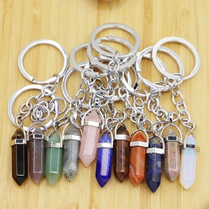 Hexagonal crystal stone keychain collection with silver metal ring on wood background