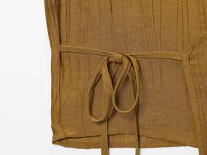 Macro view of ginger yellow crinkle fabric with side tie knot detail for 2-piece skirt set